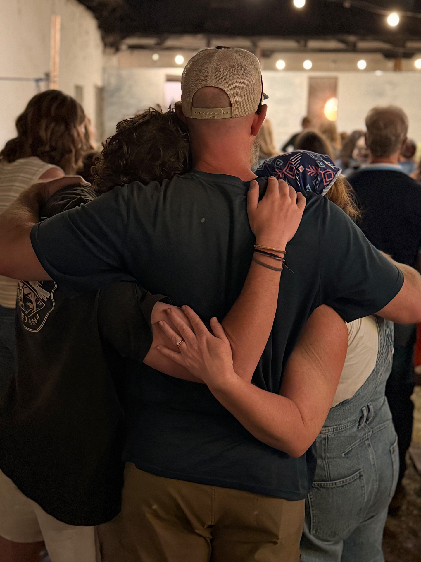 Parents and family members standing arm in arm during worship on a Parent Vision Trip