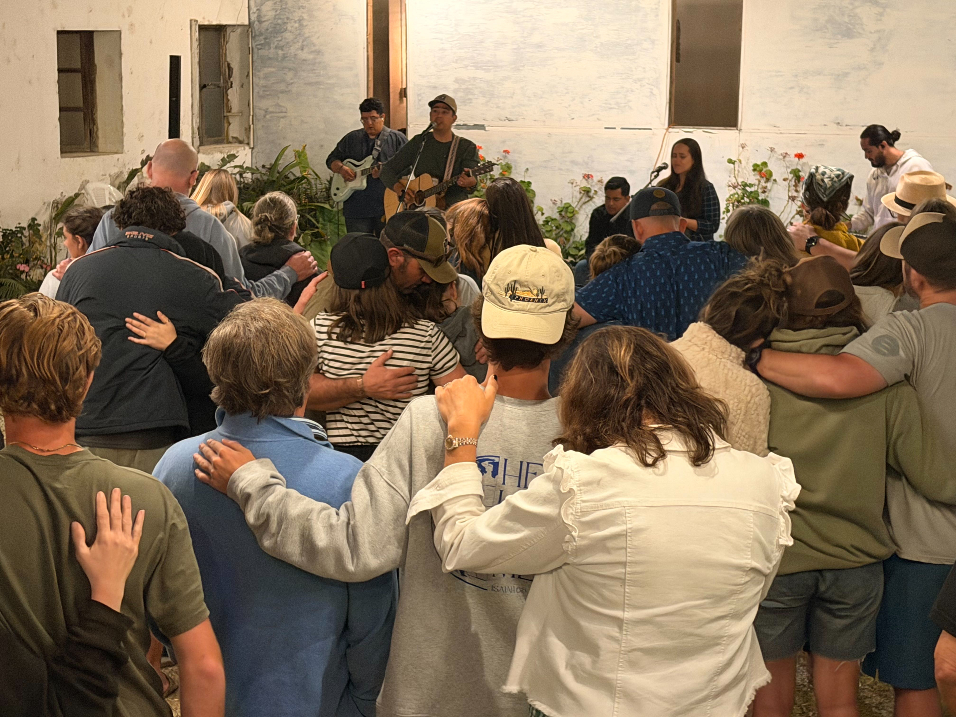 Parents and participants worshipping together in a circle during an evening gathering